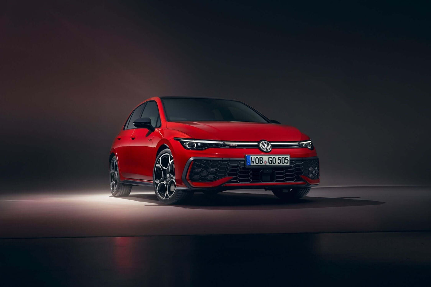 Red Volkswagen Golf showcasing its modern design and performance features in a dramatic lighting setup.